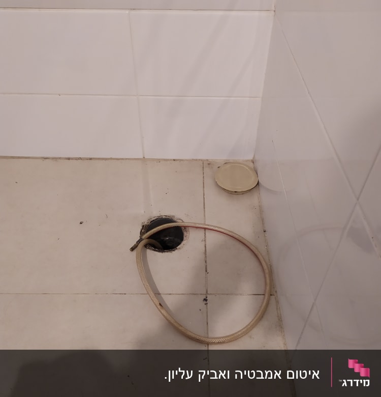 צינור מים מנותק ליד חור ניקוז ברצפה